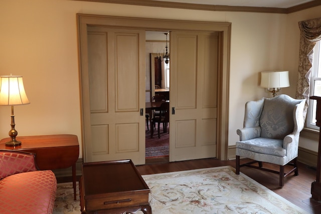 living area featuring wood finished floors and ornamental molding