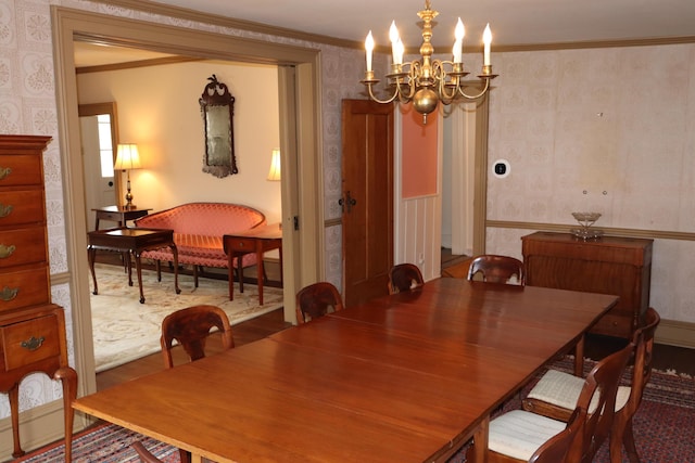 dining space featuring wallpapered walls, crown molding, and an inviting chandelier