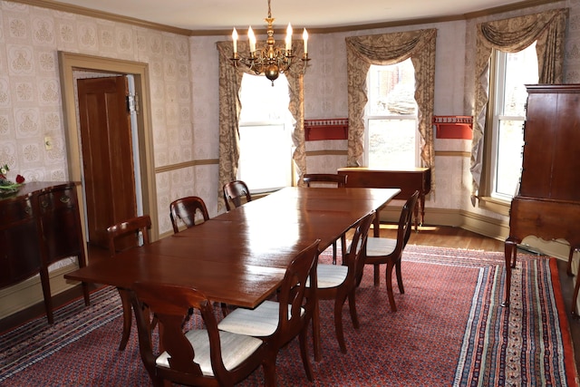 dining space with a notable chandelier, wallpapered walls, baseboards, and wood finished floors