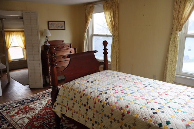 bedroom with multiple windows and wood finished floors