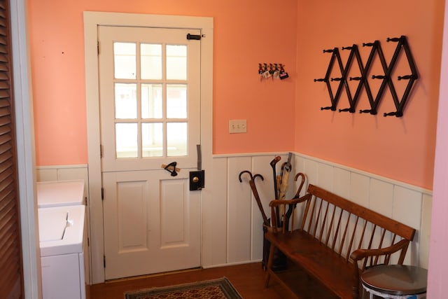 doorway to outside with a wainscoted wall and washer / clothes dryer