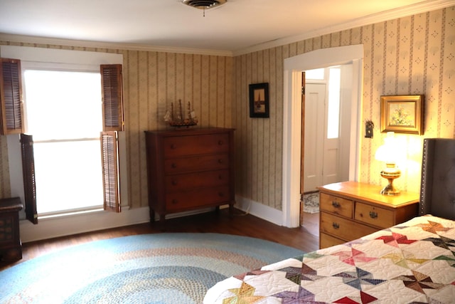 bedroom featuring baseboards, wood finished floors, ornamental molding, and wallpapered walls