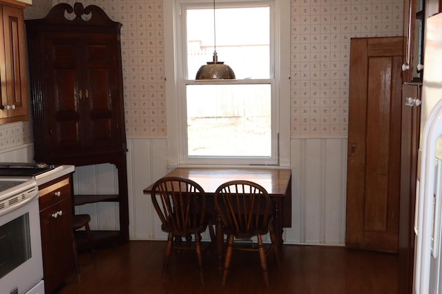 dining space featuring wallpapered walls and dark wood-type flooring