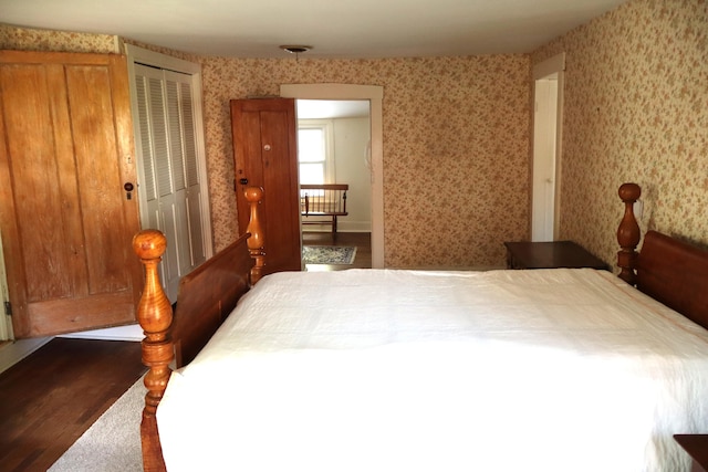 408 N Church St, Fayette, MO 65248 - bedroom featuring wallpapered walls, dark wood-style floors, and two closets