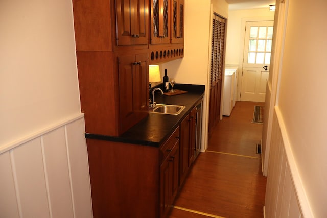 408 N Church St, Fayette, MO 65248 - kitchen with wood finished floors, dark countertops, brown cabinetry, a decorative wall, and washer / clothes dryer
