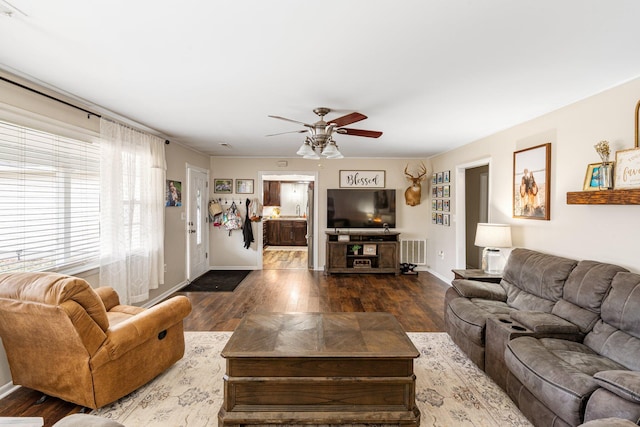 living area featuring visible vents, ceiling fan, baseboards, and wood finished floors