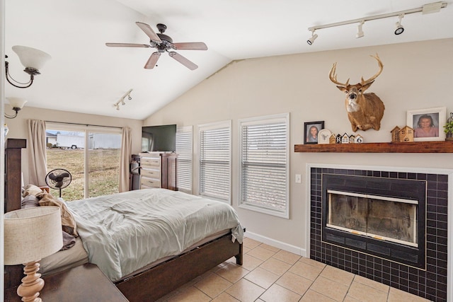 tiled bedroom with lofted ceiling, a ceiling fan, access to outside, baseboards, and a tile fireplace