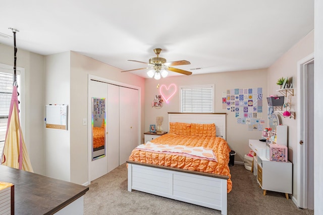 bedroom featuring a ceiling fan, a closet, and light colored carpet