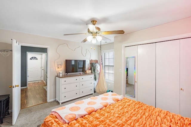 carpeted bedroom featuring a closet, ceiling fan, and baseboards