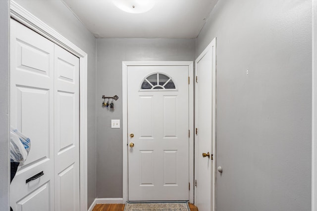 doorway to outside with baseboards and wood finished floors