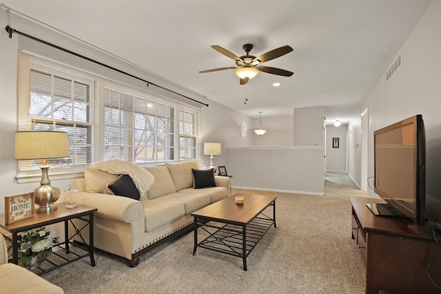 carpeted living room featuring ceiling fan, visible vents, and baseboards