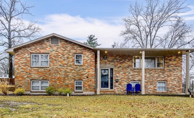 bi-level home with brick siding and a front lawn