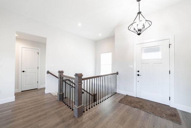 entryway with recessed lighting, wood finished floors, baseboards, and a chandelier