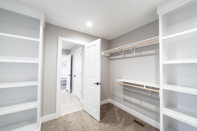 walk in closet featuring visible vents and carpet flooring