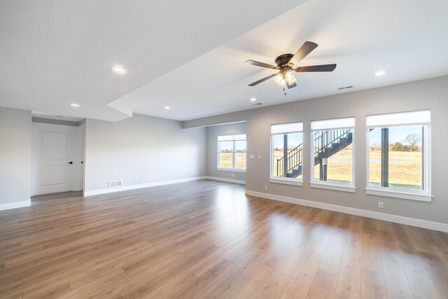 spare room featuring light wood-type flooring, visible vents, and baseboards