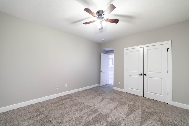 unfurnished bedroom featuring a closet, a ceiling fan, baseboards, and carpet floors