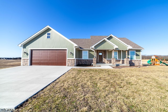 craftsman inspired home featuring a playground, concrete driveway, a front yard, stone siding, and an attached garage