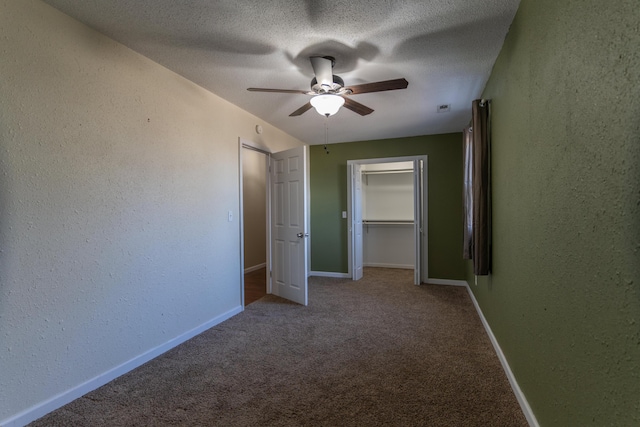 unfurnished bedroom with a textured ceiling, baseboards, carpet, and a textured wall