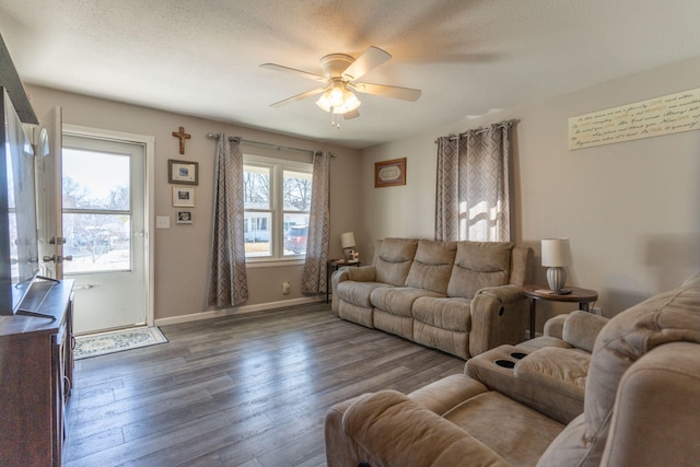 living room featuring a wealth of natural light, baseboards, dark wood-type flooring, and ceiling fan