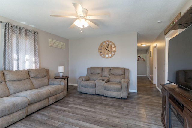 living room with a ceiling fan, wood finished floors, and baseboards