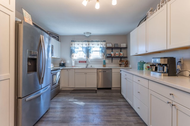 kitchen featuring a sink, stainless steel appliances, white cabinets, light countertops, and dark wood-style flooring