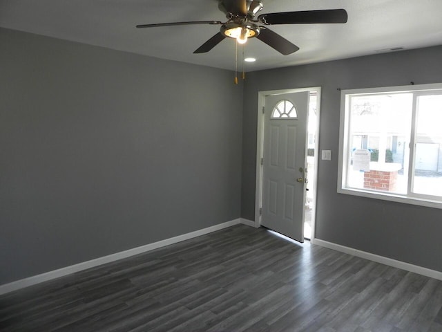 foyer entrance featuring dark wood-style floors, visible vents, baseboards, and a ceiling fan