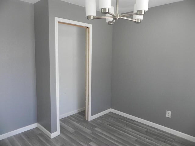 interior space with an inviting chandelier, baseboards, and dark wood-style flooring