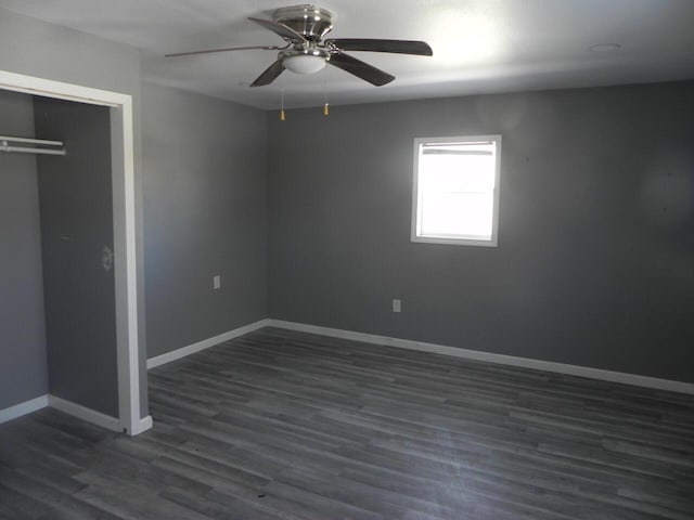 unfurnished bedroom featuring a ceiling fan, a closet, dark wood finished floors, and baseboards