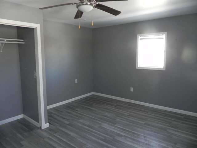 unfurnished bedroom featuring ceiling fan, a closet, baseboards, and dark wood-type flooring