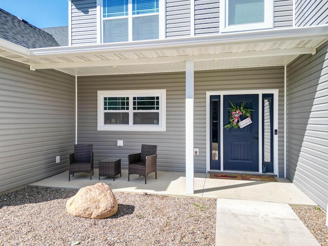 doorway to property featuring a shingled roof