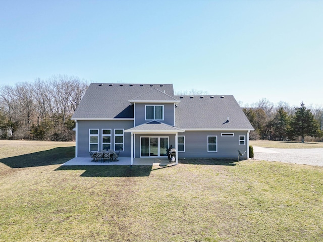 back of house featuring a patio area, a shingled roof, and a lawn