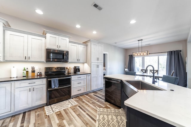 kitchen with visible vents, dishwashing machine, stainless steel microwave, double oven range, and a sink