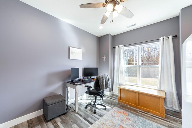 office featuring a ceiling fan, wood finished floors, visible vents, and baseboards