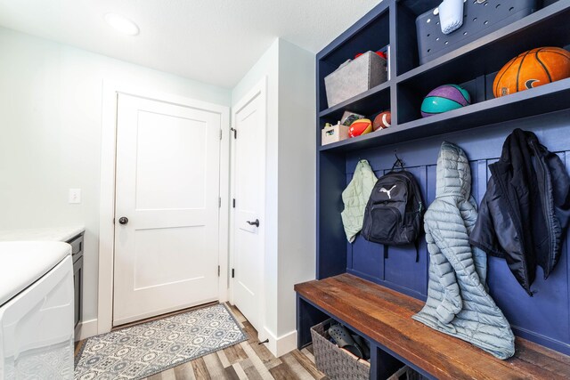 mudroom featuring separate washer and dryer, light wood-style flooring, and baseboards