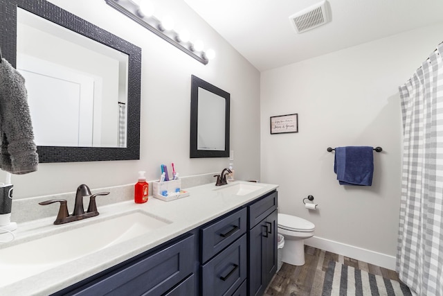 full bath featuring visible vents, a sink, toilet, and wood finished floors