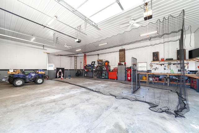 garage with metal wall, a workshop area, and a garage door opener