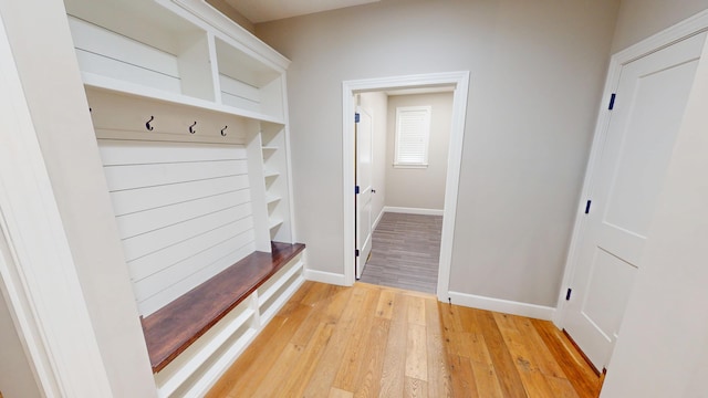 mudroom featuring light wood finished floors and baseboards