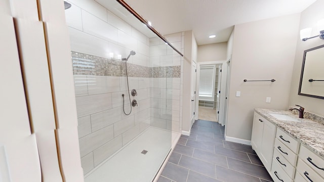 bathroom with tile patterned floors, a shower stall, vanity, and baseboards