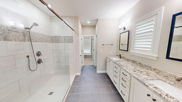 bathroom with a stall shower, a sink, and double vanity