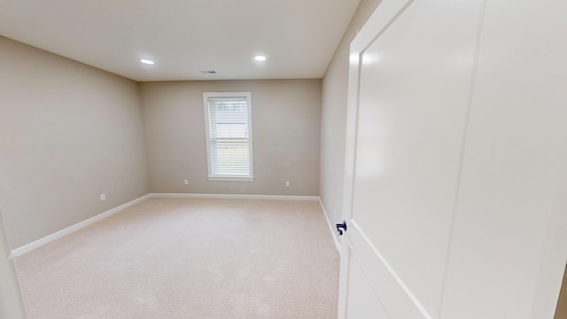 spare room with light carpet, baseboards, and recessed lighting