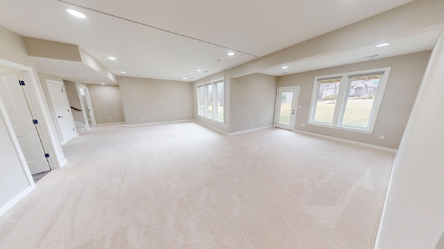 unfurnished room with recessed lighting, light carpet, plenty of natural light, and baseboards