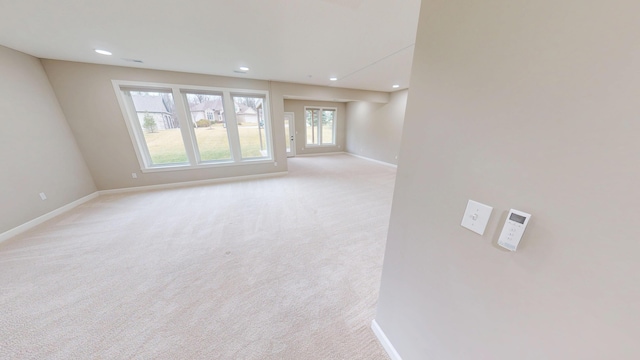 unfurnished room featuring recessed lighting, light carpet, and baseboards