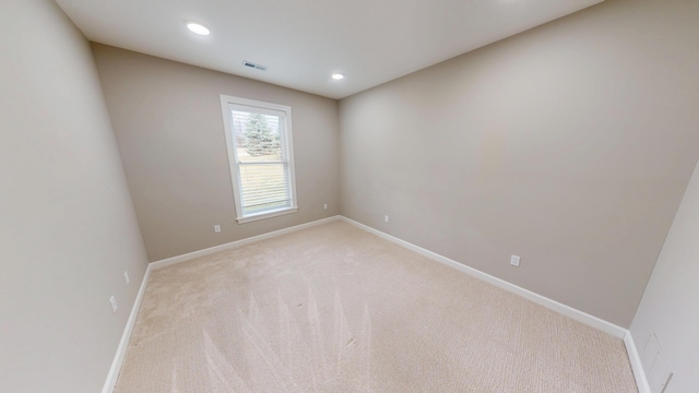 unfurnished room with recessed lighting, light colored carpet, visible vents, and baseboards