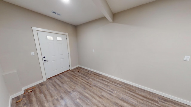 foyer entrance featuring visible vents, baseboards, and wood finished floors