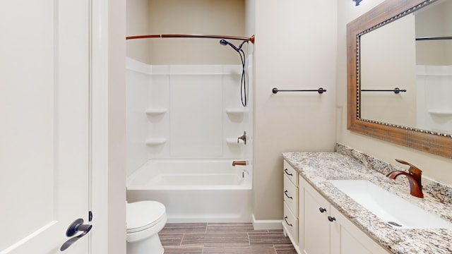 bathroom featuring toilet, wood finish floors, vanity, baseboards, and shower / bathing tub combination