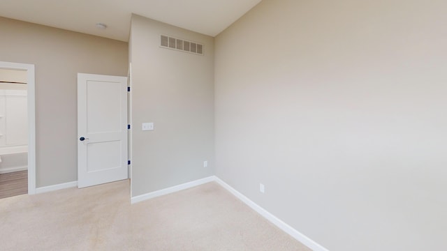 empty room with light carpet, visible vents, and baseboards