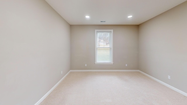 empty room with light carpet, visible vents, baseboards, and recessed lighting