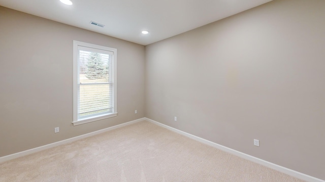 empty room with light carpet, recessed lighting, visible vents, and baseboards