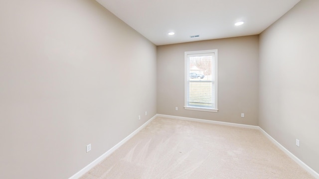 unfurnished room with recessed lighting, light carpet, visible vents, and baseboards