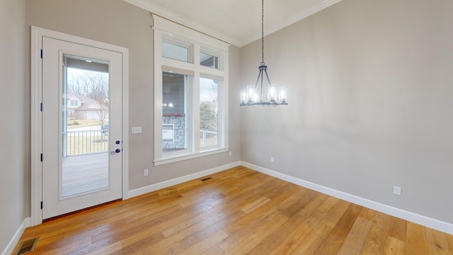 unfurnished dining area featuring light wood-style floors, visible vents, a notable chandelier, and ornamental molding